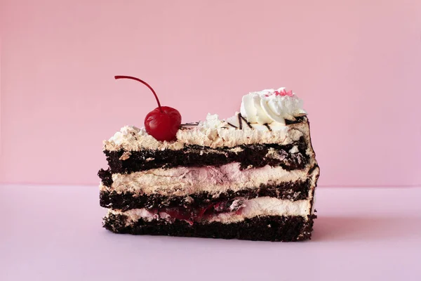ピンクの背景に赤いカクテルチェリーと誕生日のクリーミーでチョコレートケーキ — ストック写真