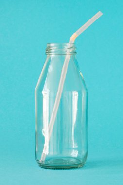 Mavi arka planda pembe renkli tüplü boş süt şişesi. Konsept - Plastiksiz 