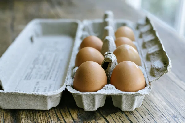 Fresh eggs in a carton on a farm table