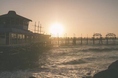 Güneş ile okyanus Redonda Beach'teki rıhtımda ayarlar.