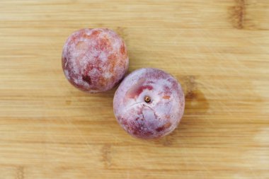 İki tatlım yumruk pluot meyve bir Ahşap Doğrama tahtası üzerinde oturmak