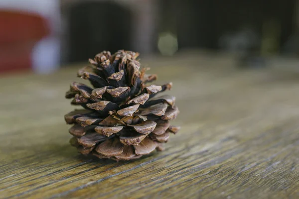 Short and stout pine cone on a farm table