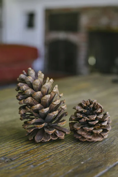 Pinecones resting on a farm table with a warm home interior view