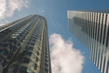 Uzun boylu gökyüzü kazıyıcılar dalgalı beyaz bulutlar ile mavi gökyüzü kadar yol