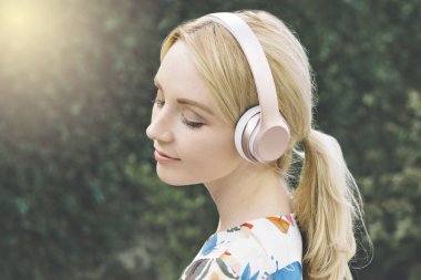 Genç beyaz kadın gözleri kapalı vardır ve onun kulaklık müzik dinleyerek taşınır