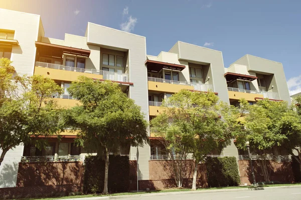 View of modern apartment building on a sunny day with warm lighting