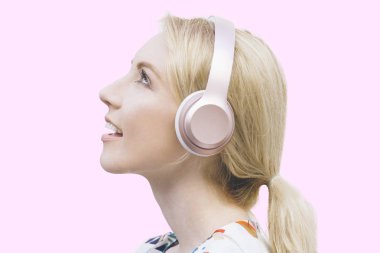 Sarı saçlı kadın kulaklıklarını dinliyor ve ilham verici