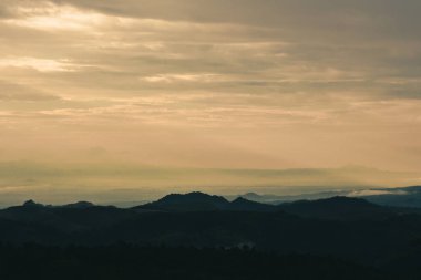 Dağlarda güzel gün doğumu. Myanmar'da turuncu bulutların arasından parlayan güneşle manzara