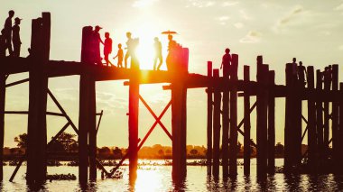 Günbatımı insanlar üzerinde köprü U-Bein akşam, Amarapura, Mandalay, Myanmar silueti ile