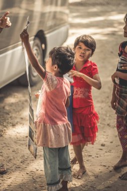 Bagan, Myanmar - 13 Şubat 2016: Birmanya kızlar eski Bagan, Myanmar gelen yabancı turist ile fotoğraf satmak