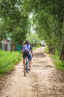 Yangon, Myanmar - 06 Haziran 2016: genç adam kırsal bir yolda Bisiklete binme ve yol boyunca doğa resimler kırsal kesimde tatile aldı..