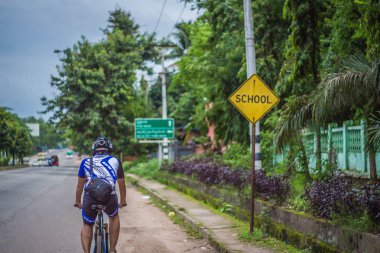 Yangon, Myanmar - 06 Haziran 2016: genç adam kırsal bir yolda Bisiklete binme ve yol boyunca doğa resimler kırsal kesimde tatile aldı..