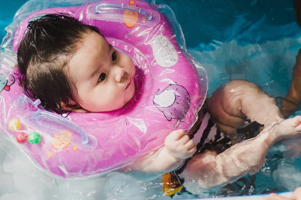 Close up portrait Asian cute baby girl 4 month-old in kit inflatable pool