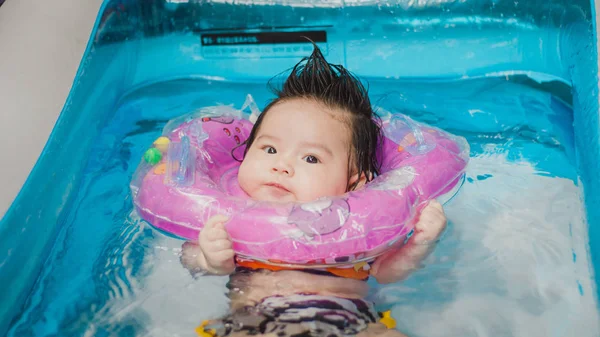 Close up portrait Asian cute baby girl 4 month-old in kit inflatable pool