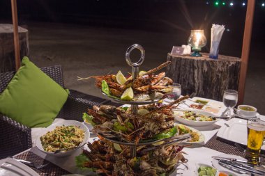 Plaj restoranının dışında akşam yemeğinde BBBQ deniz ürünleri.