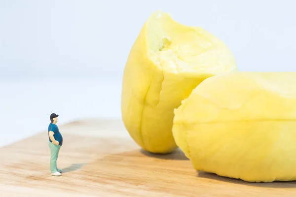 Miniature people : Close up fat man standing with durian isolated on white background
