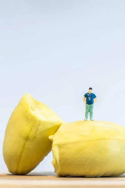 Miniature people : Close up fat man standing with durian isolated on white background