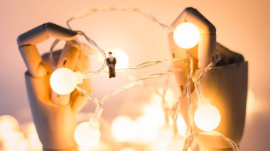 Minyatür insanlar, elektrikli tellerin üzerinde oturan genç adamı kapatın.