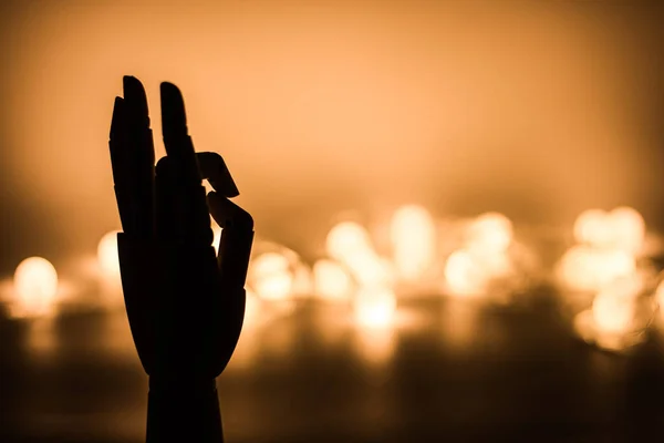 Silhouette Der Hölzernen Hand Mit Goldenen Verschwommenen Lichtern Hintergrund — Stockfoto