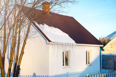 Küçük Beyaz Saray ile bir kış gününde, güneşin yatay çatı üzerinde küçük bir kar vurdu bina iciclesresidential