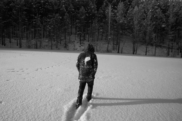 A man walking in the snow. black and white