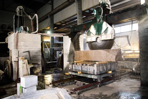 Granite processing in manufacturing. Cutting granite slab with a circular saw.