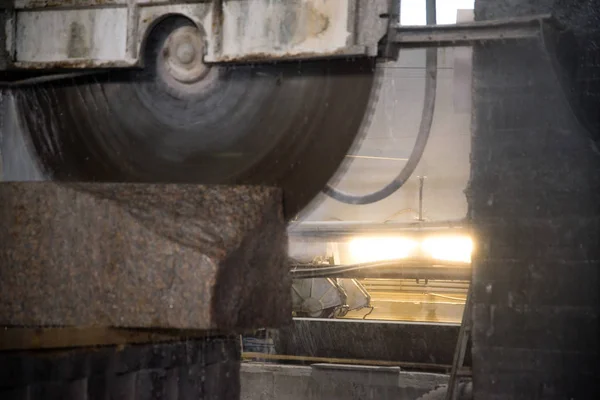 Granite processing in manufacturing. Cutting granite slab with a circular saw.