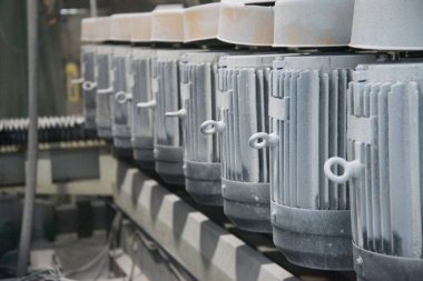 Güçlü elektrik motorları grubu. Endüstri/sanayii donatımı elektrikli sürücü. Endüstriyel arka plan. Üretimde tozlu elektrik motorları. Yumuşak odak.