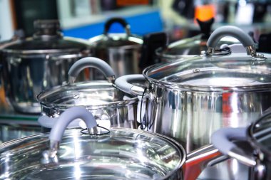 Paslanmaz çelik mutfak eşyaları raflarda ayarla.