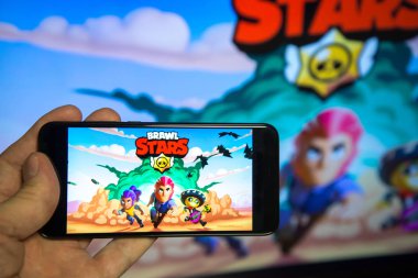 Los Angeles, California, USA - 19 February 2019: Hands holding a smartphone with BRAWL STARS game on screen background clipart