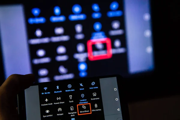 Los Angeles, Kaliforniya, ABD - 21 Şubat 2019. Ekranın arka plan üzerinde bir smartphone holding eller. Mirrorshare, uygulama yansıtma standart bir Huawei ekranıdır. Bu app Android ekranın akıllı TV'ye gönderebilir.