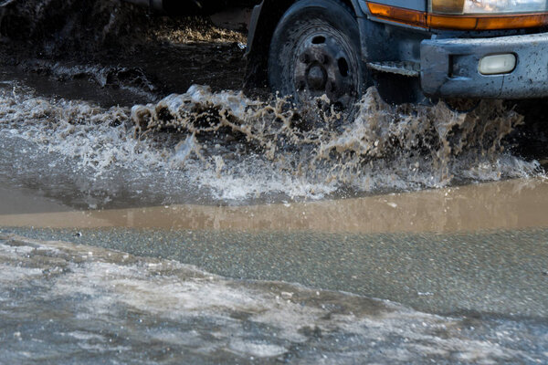 грязная волна спрея из-под колес грузовика. Вода на дороге. Распыление из-под колес автомобилей
.