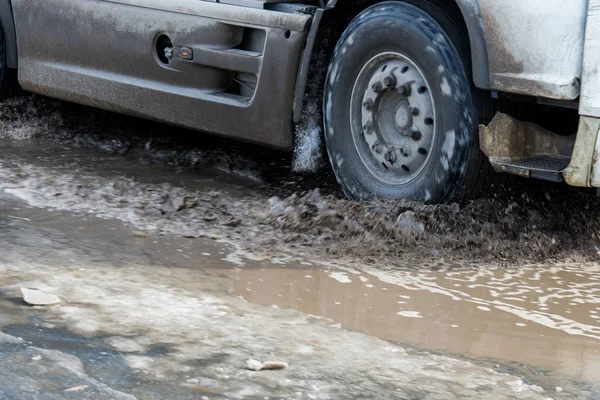 Ola sucia de spray de debajo de las ruedas de un camión. Agua en la carretera. Rocíe desde debajo de las ruedas de los coches . — Foto de Stock