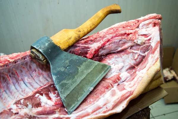 Large ax for chopping meat, meat carcass. Close up. Large piece of meat. Butcher profession