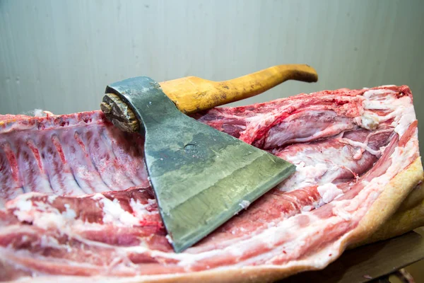 Large ax for chopping meat, meat carcass. Close up. Large piece of meat. Butcher profession