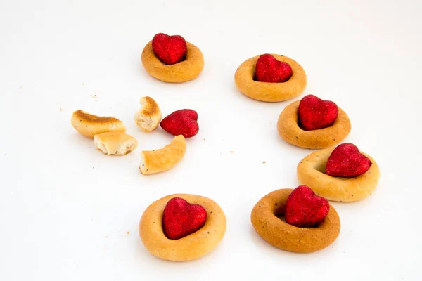 Creative image. Love and friendship. Loneliness, misunderstanding.The concept of Valentine Day. Bread rings on a white background in combination with red hearts.