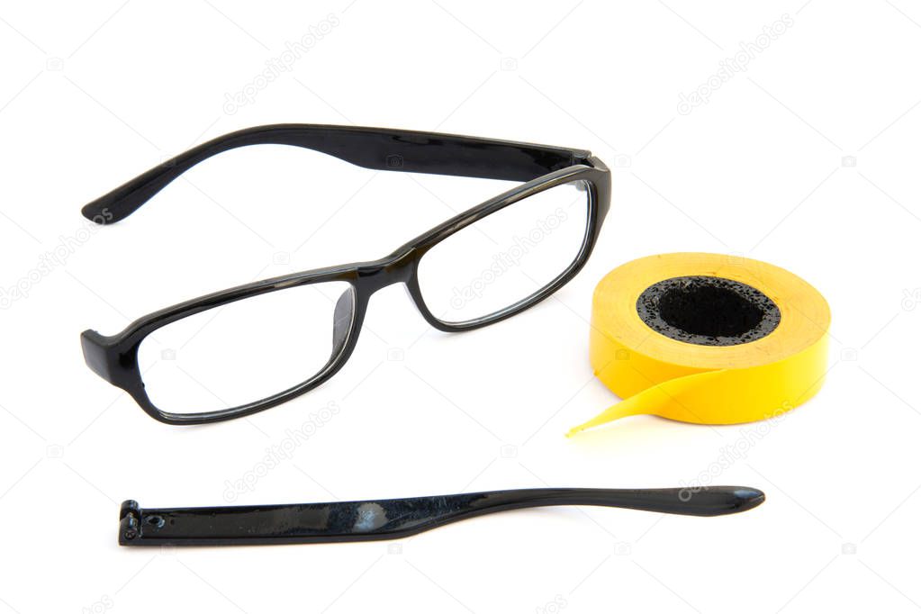 Broken eye glasses, isolated on white background. Black celluloid frame and Scotch tape