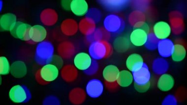 Noel ışıklarının soyut arka planı. Düzgün hareket. Rüzgardan titriyor. Defodaklanmış görüntü. Renkli Noel ışıkları.