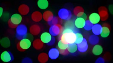Noel ışıklarının soyut arka planı. Düzgün hareket. Rüzgardan titriyor. Defodaklanmış görüntü. Renkli Noel ışıkları.
