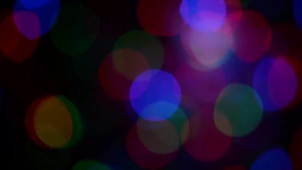 Flackernde farbige Lichter auf dunklem Hintergrund. Defokussiertes Bild. Bunte Weihnachtsbeleuchtung. — Stockvideo