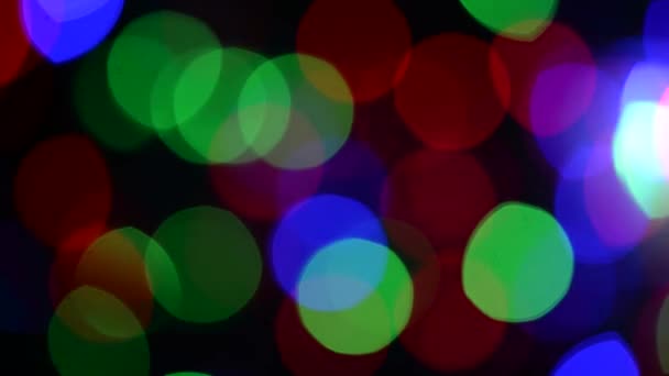 Αφηρημένο φόντο των χριστουγεννιάτικων φώτων. Ομαλή κίνηση. Τρέμει από τον άνεμο. Αποεστιασμένη εικόνα. Πολύχρωμα Χριστουγεννιάτικα φωτάκια. — Αρχείο Βίντεο