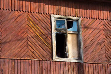 Terk edilmiş ahşap bir evin penceresi, terk edilmiş bir binanın eski yıpranmış penceresi.