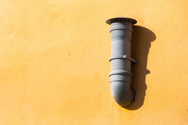 Tubo de ventilación de plástico en la pared naranja. Tubo de ventilación de aire montado en la pared exterior — Foto de Stock