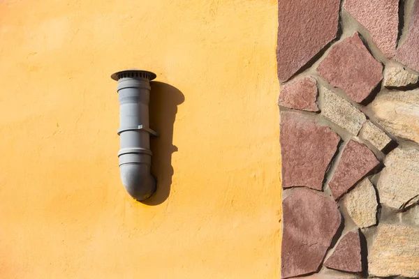 Tubo de ventilación de plástico en la pared naranja. Tubo de ventilación de aire montado en la pared exterior — Foto de Stock