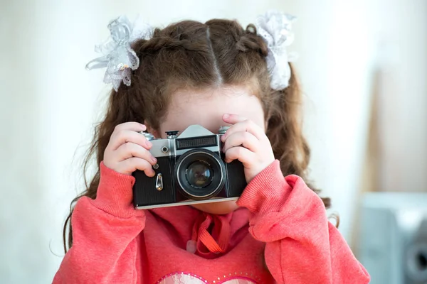 Menina com câmera vintage no fundo de luz. Bebê bonito 4-5 anos . — Fotografia de Stock