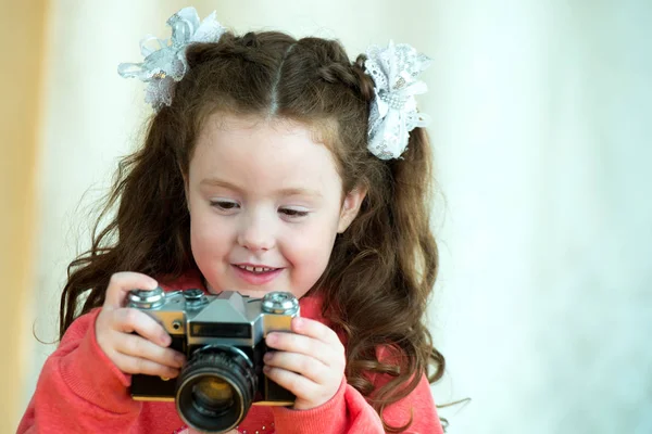 Mała dziewczynka z rocznika kamery na jasnym tle. Uśmiechnięty ładny dziecko dziewczyna 4-5 rok stary — Zdjęcie stockowe