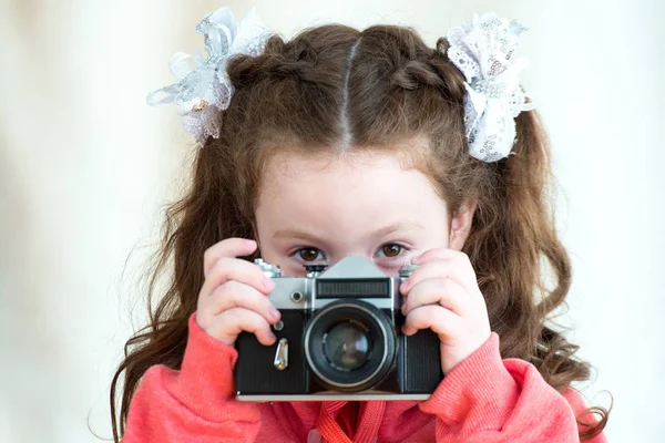 Menina com câmera vintage no fundo de luz. Menina bonito miúdo 4-5 anos de idade — Fotografia de Stock