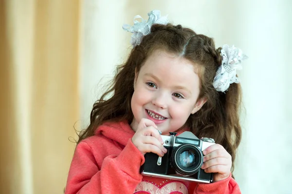 Menina com câmera vintage no fundo de luz. Sorrindo menina bonito garoto 4-5 anos de idade — Fotografia de Stock