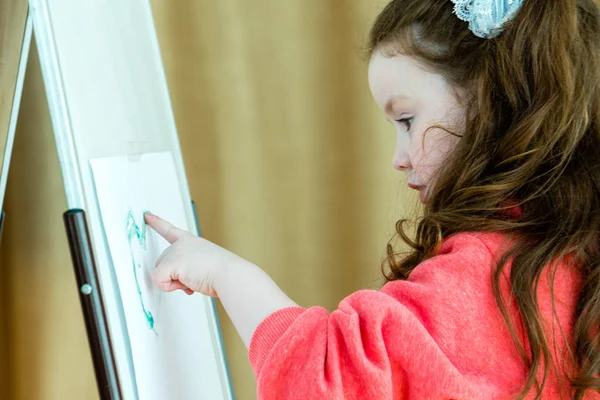 Flickan ritar ett finger, visar barnet dekorerad med gouache finger — Stockfoto