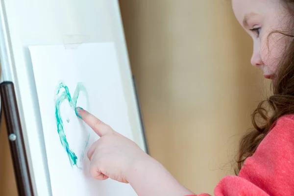 Flickan ritar ett finger, visar barnet dekorerad med gouache finger — Stockfoto